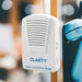 Clarity Super Loud Phone Ringer device mounted beside an analog telephone with a blurred background. 