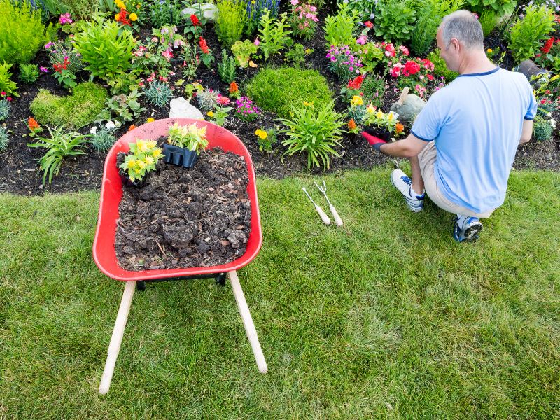 Phonak Stick 'n' Stay Hearing Aid Stickers (30 pair) 098-0353 Adhesives are great to use in the garden or when you are outdoors.  Man sitting on the lawn beside a flower bed. 